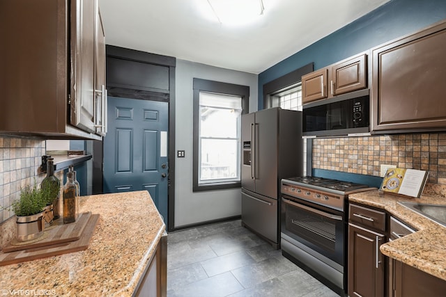 kitchen featuring dark brown cabinets, stainless steel appliances, decorative backsplash, and light stone counters