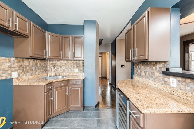 kitchen with dark hardwood / wood-style floors, sink, beverage cooler, light stone counters, and tasteful backsplash