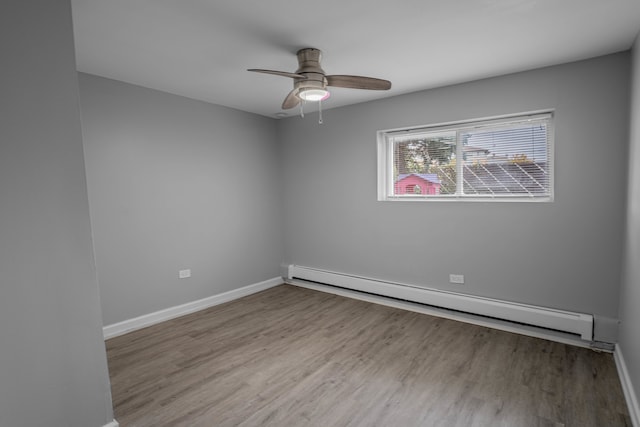 spare room with a baseboard heating unit, light hardwood / wood-style floors, and ceiling fan