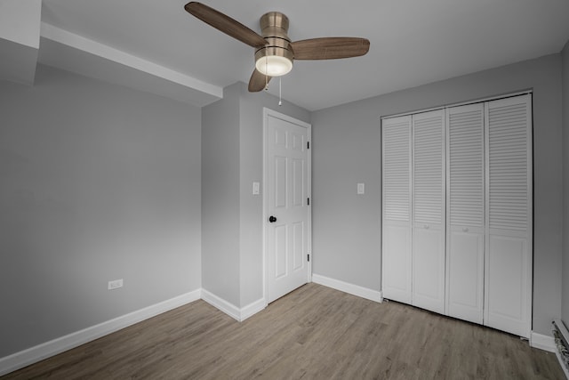 unfurnished bedroom with light hardwood / wood-style floors, a closet, and ceiling fan