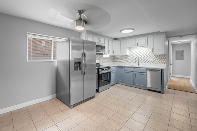 kitchen featuring decorative backsplash, stainless steel appliances, sink, light tile patterned floors, and ceiling fan