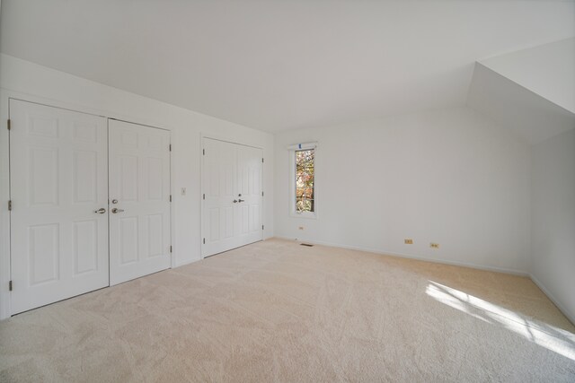 bonus room featuring lofted ceiling and light carpet