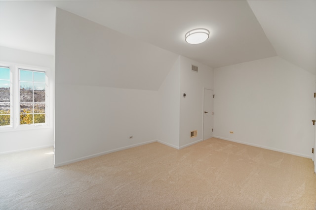 bonus room featuring lofted ceiling and light colored carpet