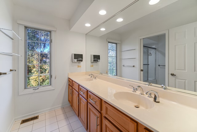bathroom with vanity, a shower with door, plenty of natural light, and tile patterned flooring