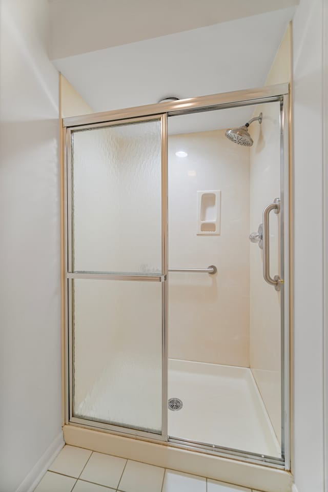 bathroom featuring a shower with door and tile patterned floors