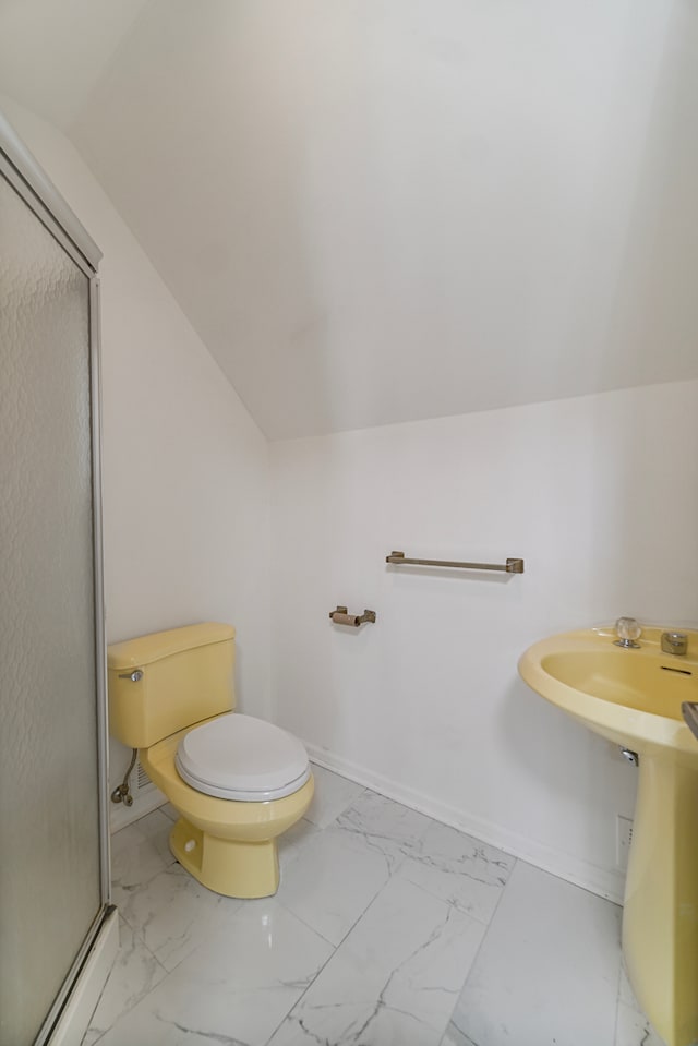 bathroom with lofted ceiling, toilet, and an enclosed shower