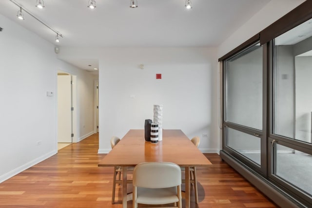 dining room with rail lighting and light hardwood / wood-style floors