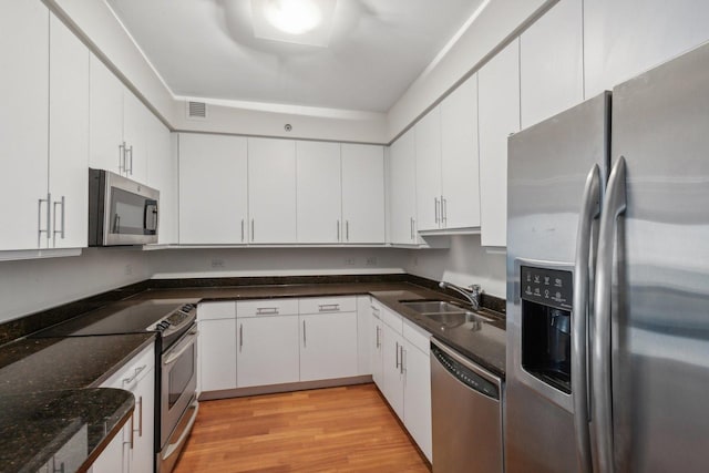 kitchen featuring white cabinetry, appliances with stainless steel finishes, and light hardwood / wood-style flooring