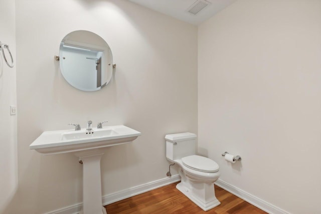 bathroom with wood-type flooring and toilet