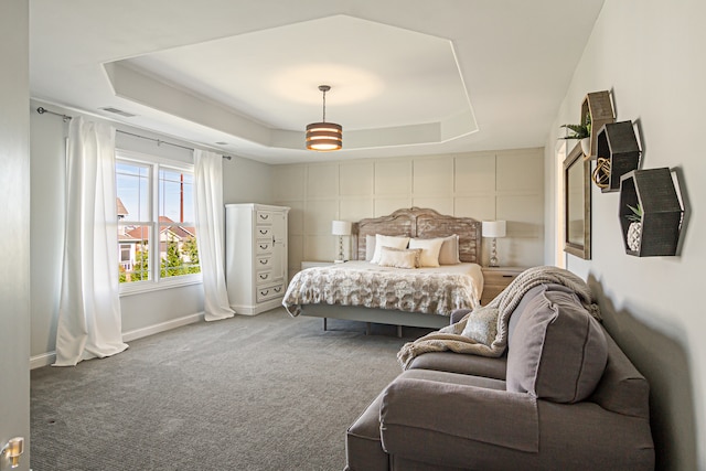 carpeted bedroom with a tray ceiling