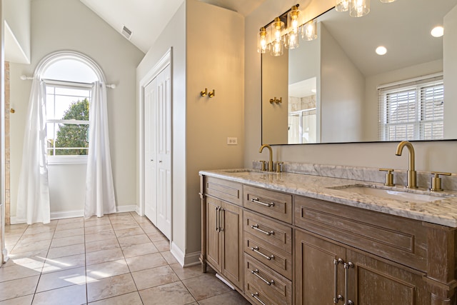 bathroom featuring vanity, lofted ceiling, tile patterned floors, and a wealth of natural light