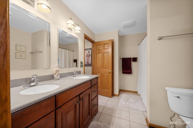 bathroom featuring tile patterned flooring, vanity, and toilet