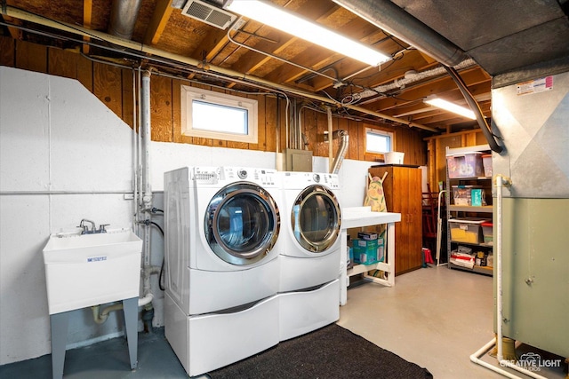 clothes washing area featuring separate washer and dryer and sink