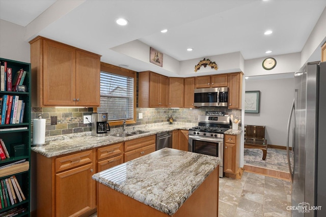 kitchen with sink, a center island, stainless steel appliances, tasteful backsplash, and light stone counters