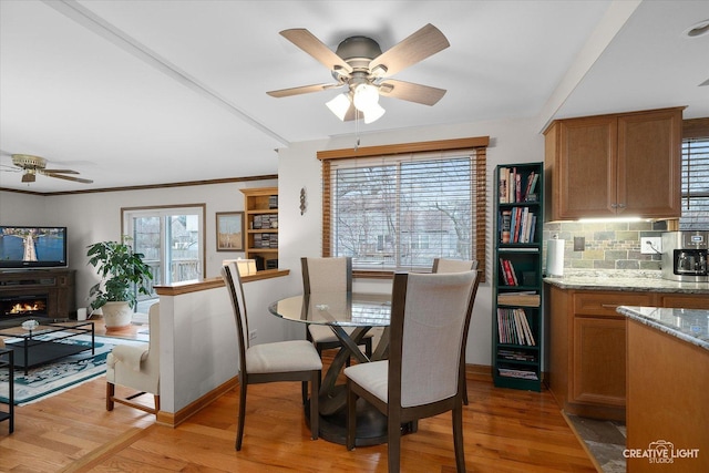 dining area with ceiling fan, crown molding, and light hardwood / wood-style floors