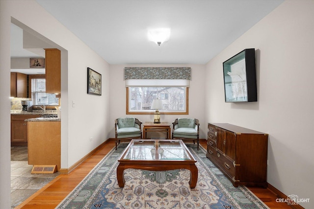 sitting room with light wood-type flooring and sink