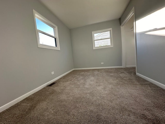 unfurnished bedroom featuring carpet and multiple windows