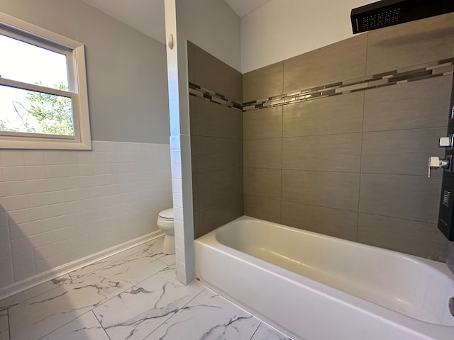 bathroom featuring toilet and tile walls