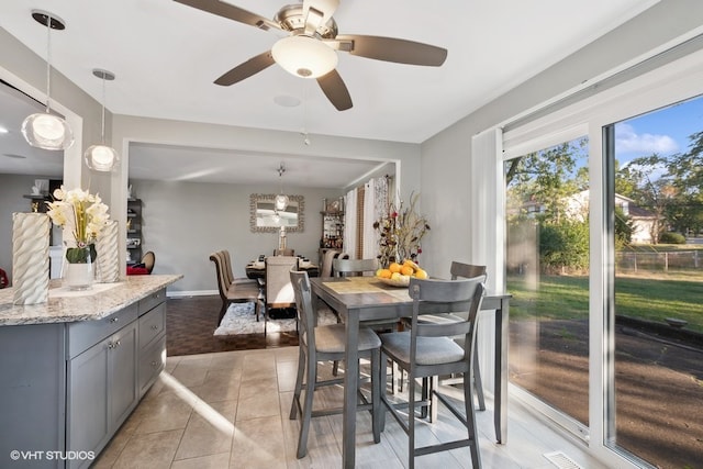 tiled dining room featuring ceiling fan