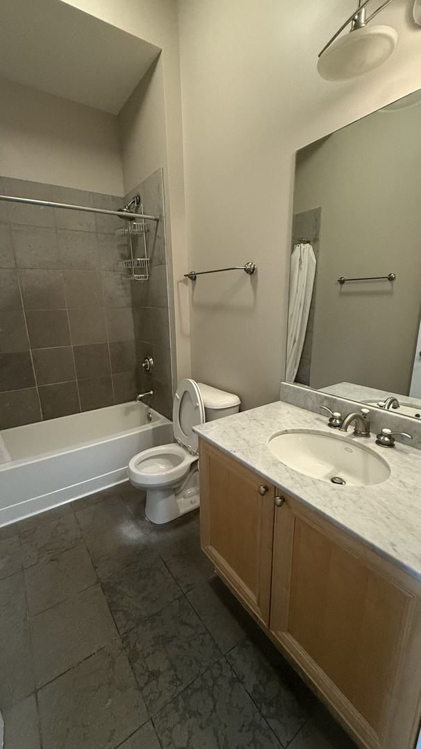 full bathroom featuring vanity, shower / bath combo with shower curtain, and toilet