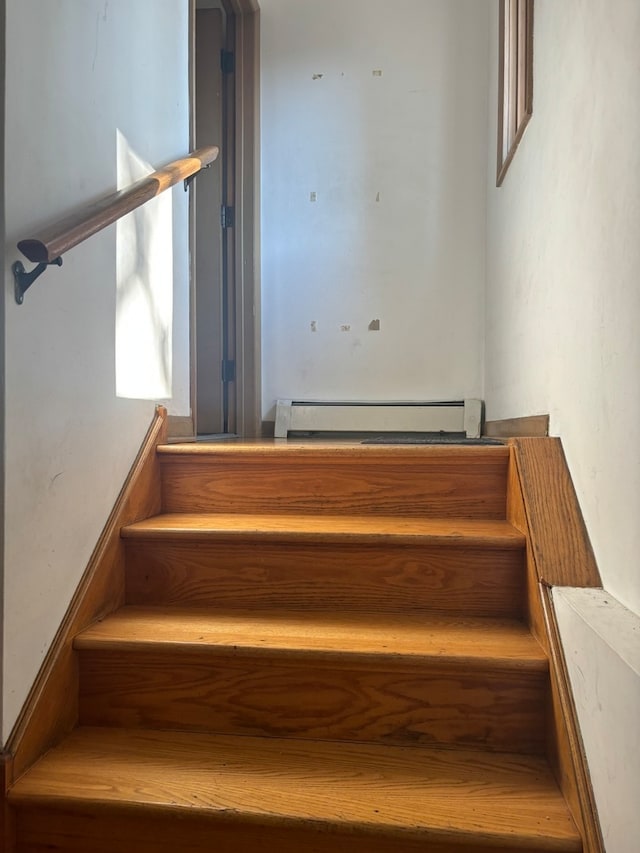 stairs with a baseboard radiator