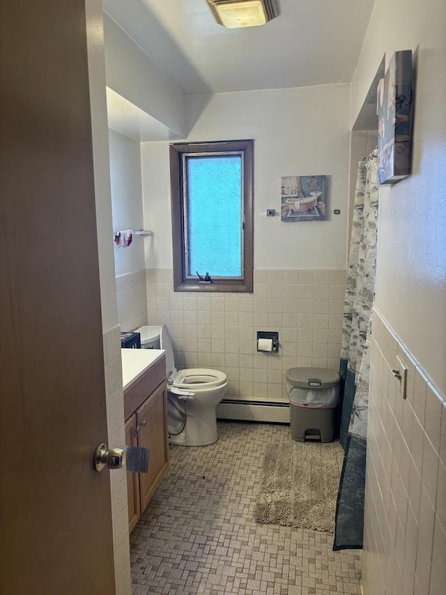 9270 N Courtland Dr, Niles, IL 60714 - bathroom featuring a baseboard heating unit, tile walls, wainscoting, toilet, and vanity