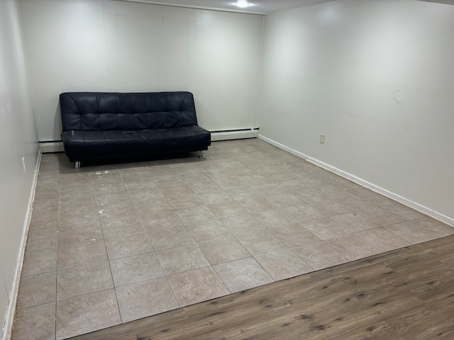 living area with baseboard heating and light hardwood / wood-style flooring