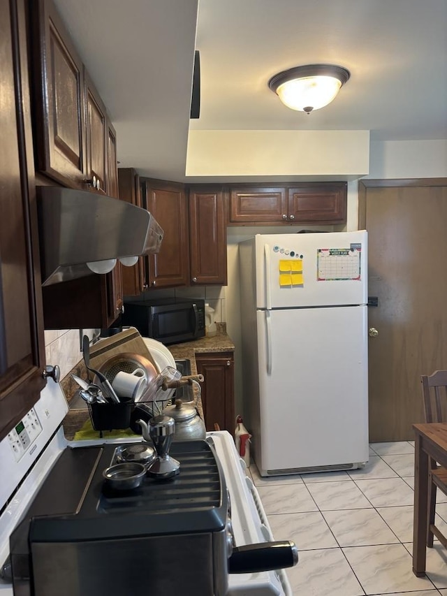 9270 N Courtland Dr, Niles, IL 60714 - kitchen with under cabinet range hood, freestanding refrigerator, black microwave, and dark brown cabinets