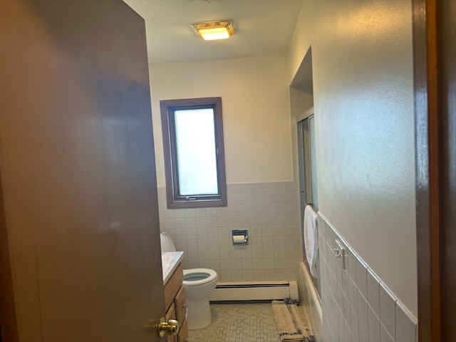 full bathroom featuring toilet, tile patterned flooring, baseboard heating, tile walls, and vanity