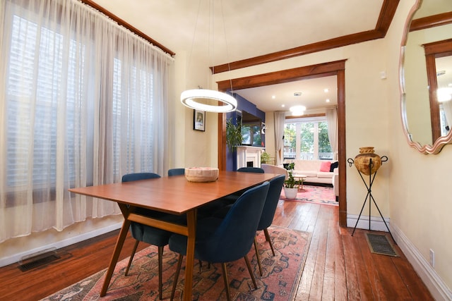 dining space with hardwood / wood-style flooring and ornamental molding