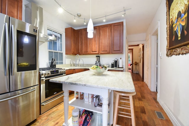 kitchen featuring a breakfast bar, light hardwood / wood-style flooring, stainless steel appliances, and sink