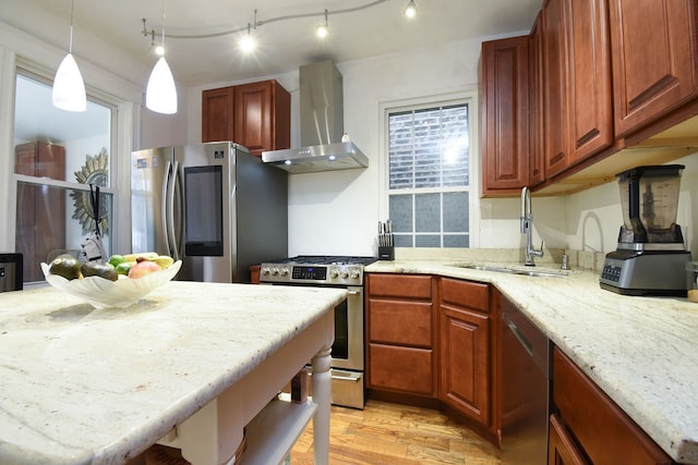 kitchen featuring light stone countertops, sink, wall chimney range hood, light hardwood / wood-style floors, and appliances with stainless steel finishes