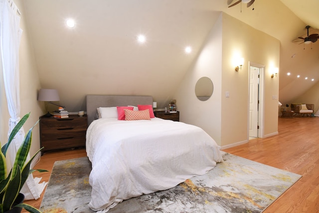 bedroom featuring ceiling fan, light hardwood / wood-style floors, and lofted ceiling