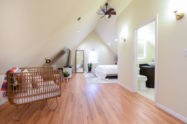 bedroom with hardwood / wood-style floors, ceiling fan, lofted ceiling, and connected bathroom