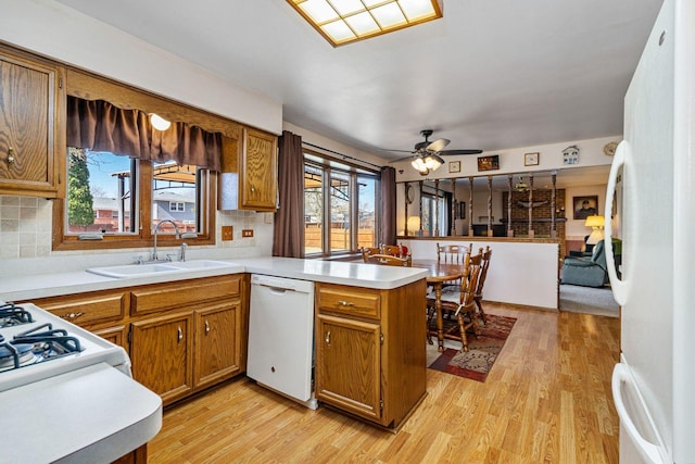 1617 Cimarron Dr, New Lenox, IL 60451 - kitchen featuring white appliances, a peninsula, light wood-style flooring, brown cabinets, and plenty of natural light