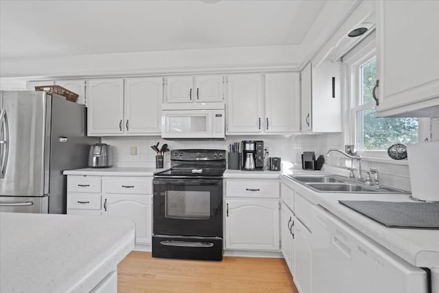 kitchen featuring white appliances, light hardwood / wood-style floors, decorative backsplash, and white cabinets