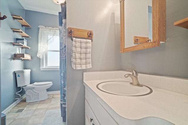 bathroom featuring vanity, toilet, and tile patterned flooring