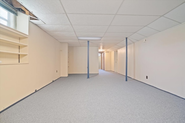 basement featuring light carpet and a drop ceiling