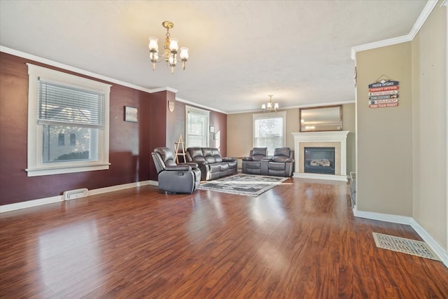 living room with an inviting chandelier, crown molding, hardwood / wood-style flooring, and a tile fireplace