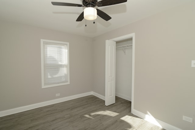 unfurnished bedroom featuring a closet, ceiling fan, and dark hardwood / wood-style flooring