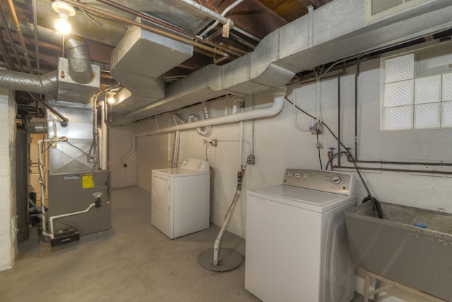 basement with heating unit, sink, and separate washer and dryer