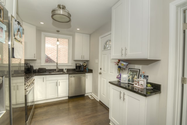 kitchen featuring appliances with stainless steel finishes, white cabinetry, sink, and dark hardwood / wood-style floors