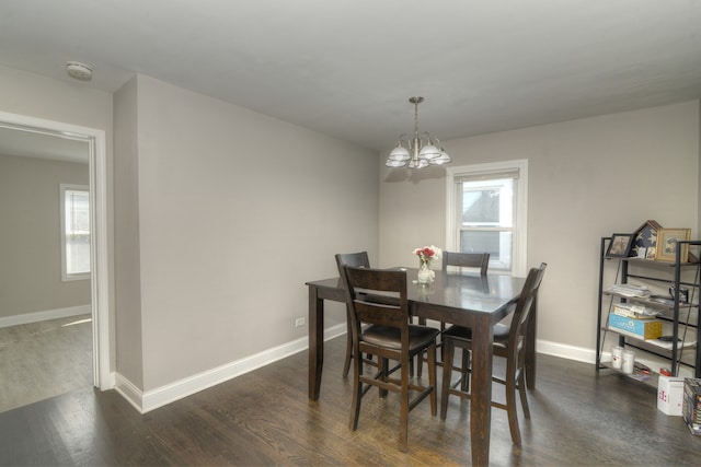 dining room featuring dark hardwood / wood-style flooring, a wealth of natural light, and an inviting chandelier