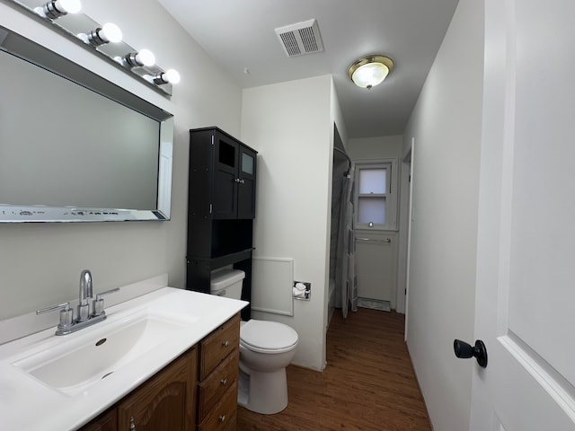 bathroom with vanity, toilet, a shower with shower curtain, and hardwood / wood-style floors