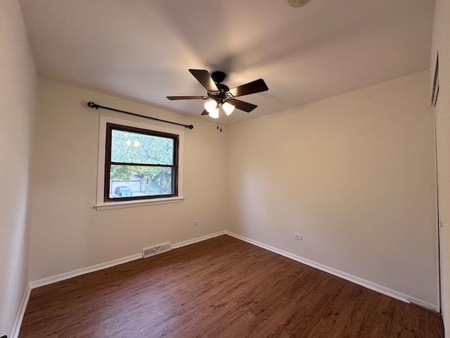 empty room featuring dark wood-type flooring and ceiling fan