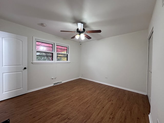 unfurnished bedroom featuring a closet, dark hardwood / wood-style floors, and ceiling fan