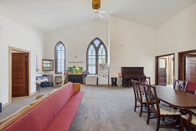 dining area featuring light colored carpet, high vaulted ceiling, and ceiling fan