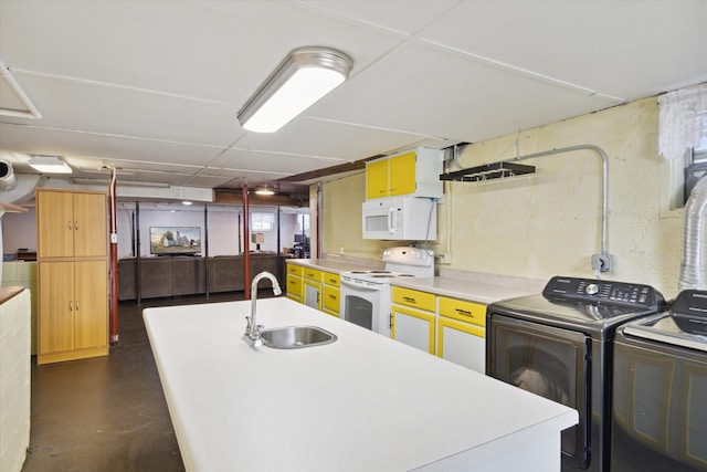 kitchen with a center island with sink, sink, washer and clothes dryer, and white appliances