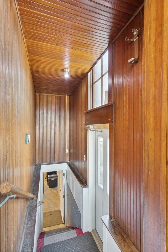 interior space featuring wood ceiling and wooden walls