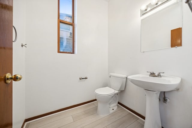 bathroom featuring wood-type flooring and toilet